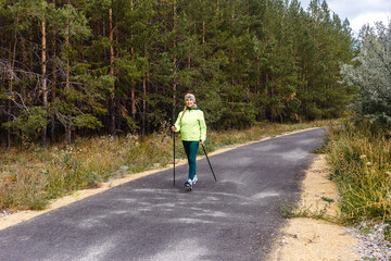 fifty-year-old woman walks down the road with sticks