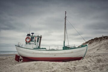 Fischerboot liegt am Nordseestrand bei Ebbe