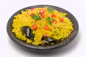 Indian breakfast Poha garnished with pomegranate seeds, chopped green chilly, coriander leaves and curry leaves.