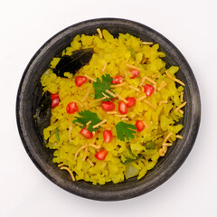 Indian breakfast Poha garnished with pomegranate seeds, chopped green chilly, coriander leaves and curry leaves.