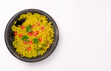 Indian breakfast Poha garnished with pomegranate seeds, chopped green chilly, coriander leaves and curry leaves.