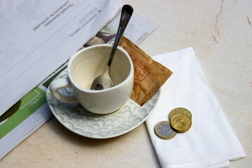 Close-up of a mug next to tip payment on a bar table