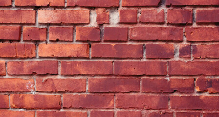 Red and orange brick old wall with defects