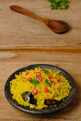 Indian breakfast Poha garnished with pomegranate seeds, chopped green chilly, coriander leaves and curry leaves.