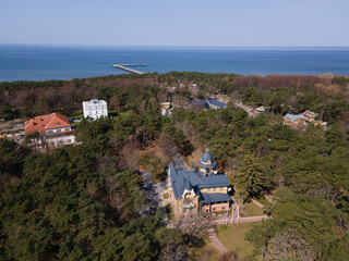 Obraz premium Aerial panoramic view of Palanga resort, Palanga city museum and other building among pines with a sea bridge in the distance in Baltic sea