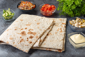 Pita bread sheets.Lavash. Pita bread sheets on a dark background with ingredients for shawarma. Shawarma with chicken