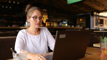 Freelancer woman opens her laptop, facial recognition system gets face detection scanning to access the computer. Infrared camera scans female face. Biometry in electronics. Female starts work in cafe - Powered by Adobe