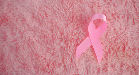 pink ribbon breast cancer on a pink silk background. with copy space. breast cancer awareness...