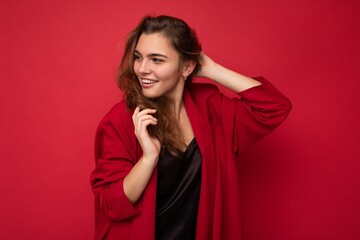 Photo portrait of beautiful happy funny young brunette woman in stylish red cardigan. Sexy carefree female person posing isolated on red background. Positive model shows sincere emotions