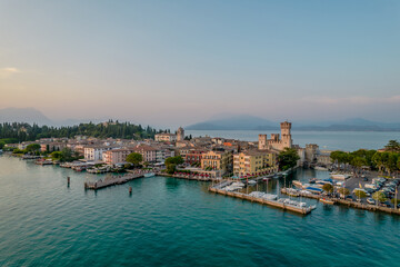 Fototapeta na wymiar Aerial panoramic view of Sirmione city old town on lake Garda in Lombardy, Italy. Evening photo with a castle in a center