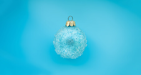 blue christmas ball with some bumps on a blue background. Minimal Christmas design, place for text