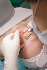 A woman aged at the reception of a beautician. Facial care, skin cleansing and wrinkle elimination