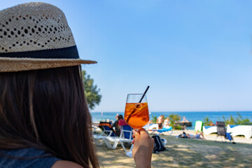 Woman drinking a long drink cocktail on the beach in Piran Slovenia