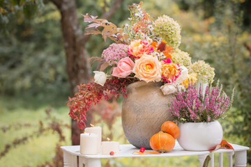 beautiful autumn decor with flowers, berries, pumpkins in garden