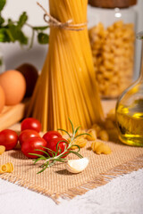 Pasta and its ingredients on a bright background. Copy space.