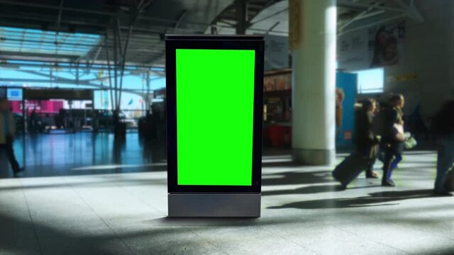 Green Screen Panel Airport People Walking Behind Billboard. Digital panel green screen inside an airport with people walking behind. Pre Keyed