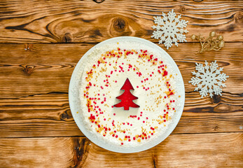 Christmas cake with white cream and a red gold  Christmas tree made of sprinkles. Homemade Christmas cake in red and gold flat lay copy space. Christmas food background top view