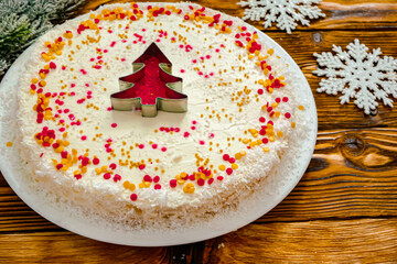 Christmas cake with white cream and a red gold  Christmas tree made of sprinkles. Homemade Christmas cake in red and gold flat lay copy space. Christmas food background top view