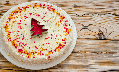 Christmas cake with white cream and a red gold  Christmas tree made of sprinkles. Homemade Christmas cake in red and gold flat lay copy space. Christmas food background top view