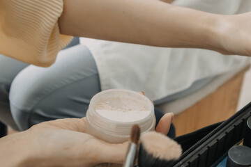 Naklejka premium The makeup artist is using makeup tools applying to the client.