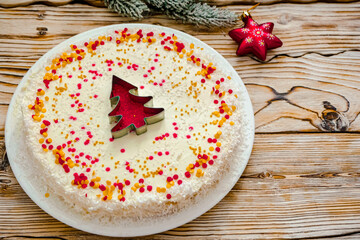 Christmas cake with white cream and a red gold  Christmas tree made of sprinkles. Homemade Christmas cake in red and gold flat lay copy space. Christmas food background top view