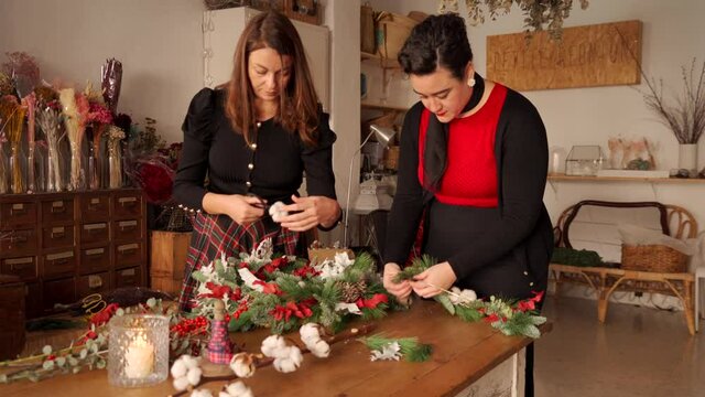 Women making Christmas wreath together