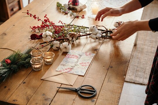 Person working on festive Christmas bouquet on table