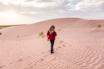 Unrecognizable Woman walking on desert dunes