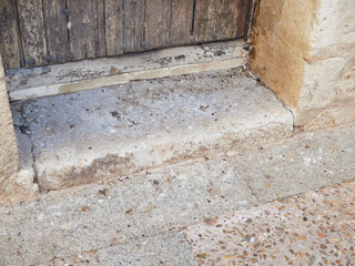 Detail of the entrance door of a monument in Spain covered in pigeon feathers and feces. Concern of the public authorities for the problem of the damage they can cause to the stones of the monuments.