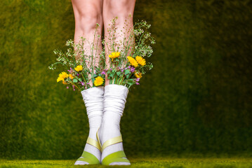feet in the grass with flowers flowers in socks green background