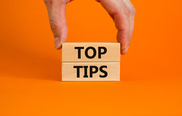 Top tips symbol. Concept words Top tips on wooden blocks on a beautiful orange background....