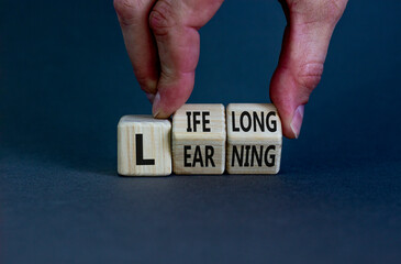 Lifelong learning symbol. Businessman turns wooden cubes with concept words 'Lifelong learning' on...
