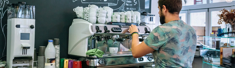 Male barista preparing coffee machine indoors