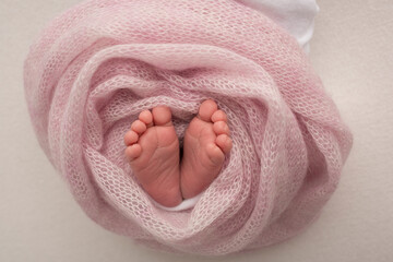 Close up picture of new born baby feet on a pink plaid