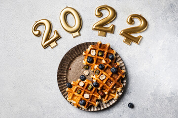 Waffles with honey and blueberry for christmas. New year dish. 2022 year. Kids dish for christmas. Waffles top view