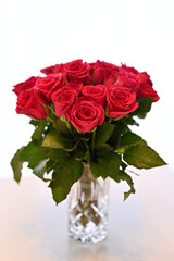 Pink roter Rosenstrauß vor hellem weißen Hintergrund in einer Vasea