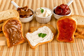 Toasted bread with jam, dulce de leche and ricotta cream on a breakfast table.