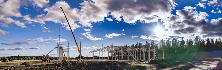 Fototapeta premium Construction site of Steel frame structure on sky background. High crane, wide scenic panorama