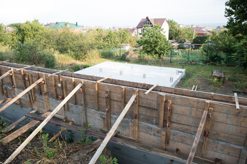 Construction site. The timber formwork is prepared for pouring concrete. The metal fittings are also visible. The process of building a private house