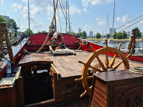 The large wooden steering wheel of the sailing ship Standart moored at the pier in the Lavtian capital Riga in July 2021