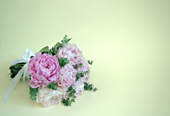 bouquet of pink peonies on a yellow background  