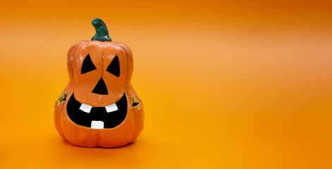 Festive pumpkin. Jack o lantern with smile with teeth and sparkles on orange background. Banner. Halloween. Copy space