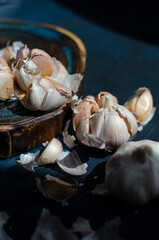 heads of garlic on a table with fresh herbs