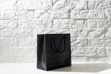 black paper bag with handles on a white background
