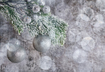 pine branch with christmas tree decorations on grey background