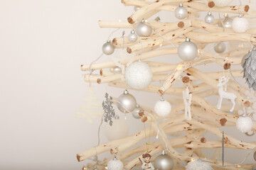 Christmas decoration. New Year's silver, white toys and with lights on a wooden Christmas tree. Christmas background for postcard. Scandinavian style