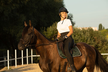 Young woman preparing to become a riding instructor taking care and talking to a horse.