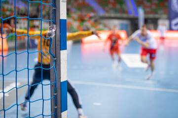 Detail of handball goal post with net and penalty shot in the background. - obrazy, fototapety, plakaty
