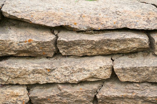 Close-up of a detailed picture of a stone wall. Old stone wall texture background for design and decor. High quality photo