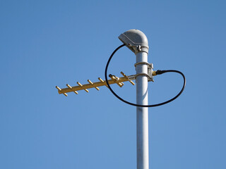 UHF radio antenna on pole against blue sky landscape format